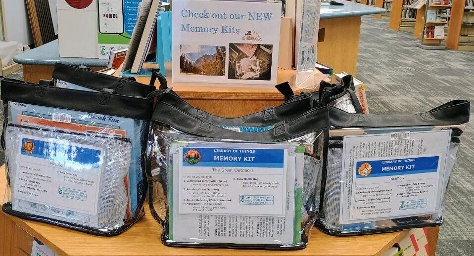 Memory care kits displayed on a shelf in a library.